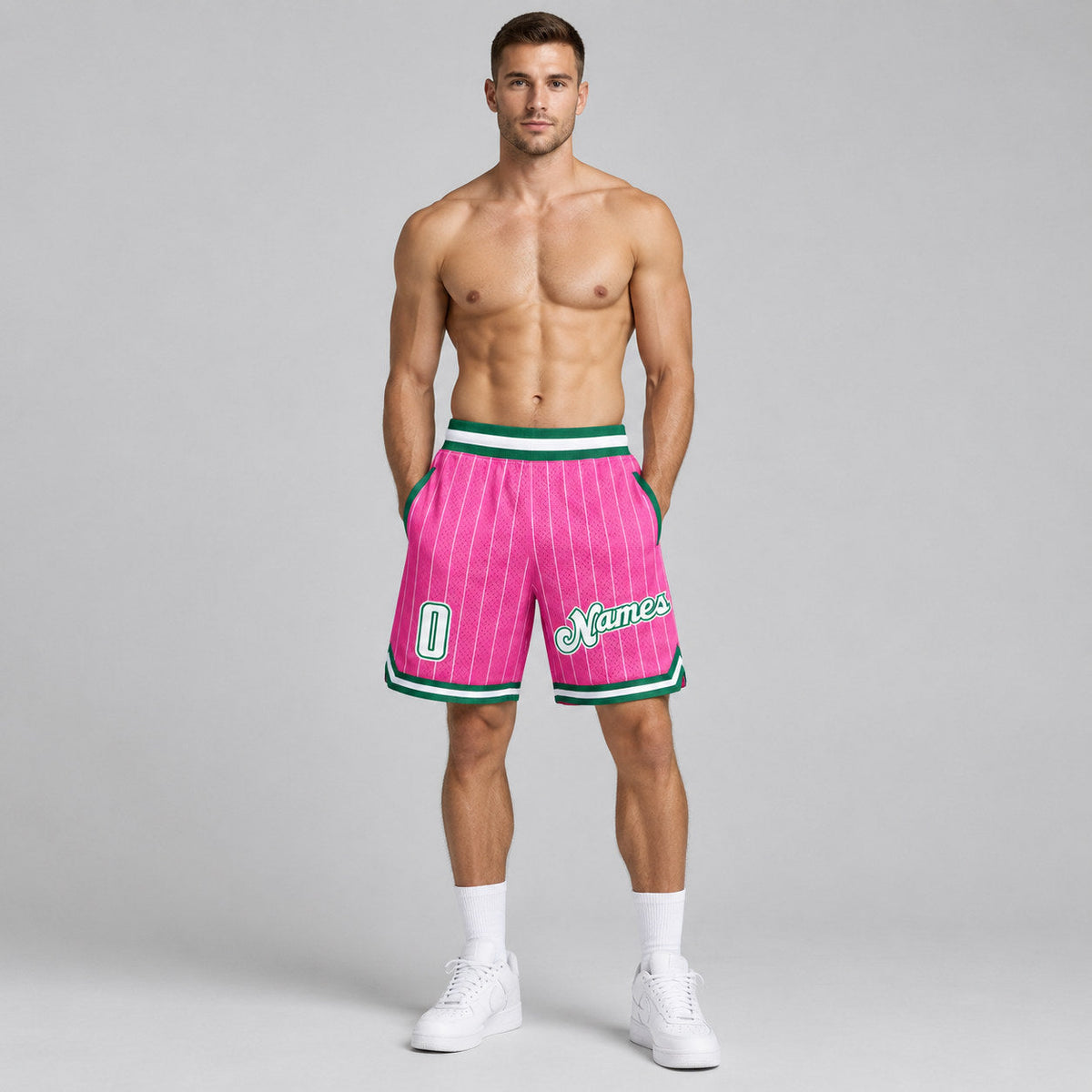 Custom Pink and White Pinstripe Authentic Basketball Shorts with White and Kelly Green Lettering worn by male model