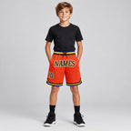 Custom Orange Authentic Throwback Basketball Shorts with Navy and Gold Lettering youth size worn by child model