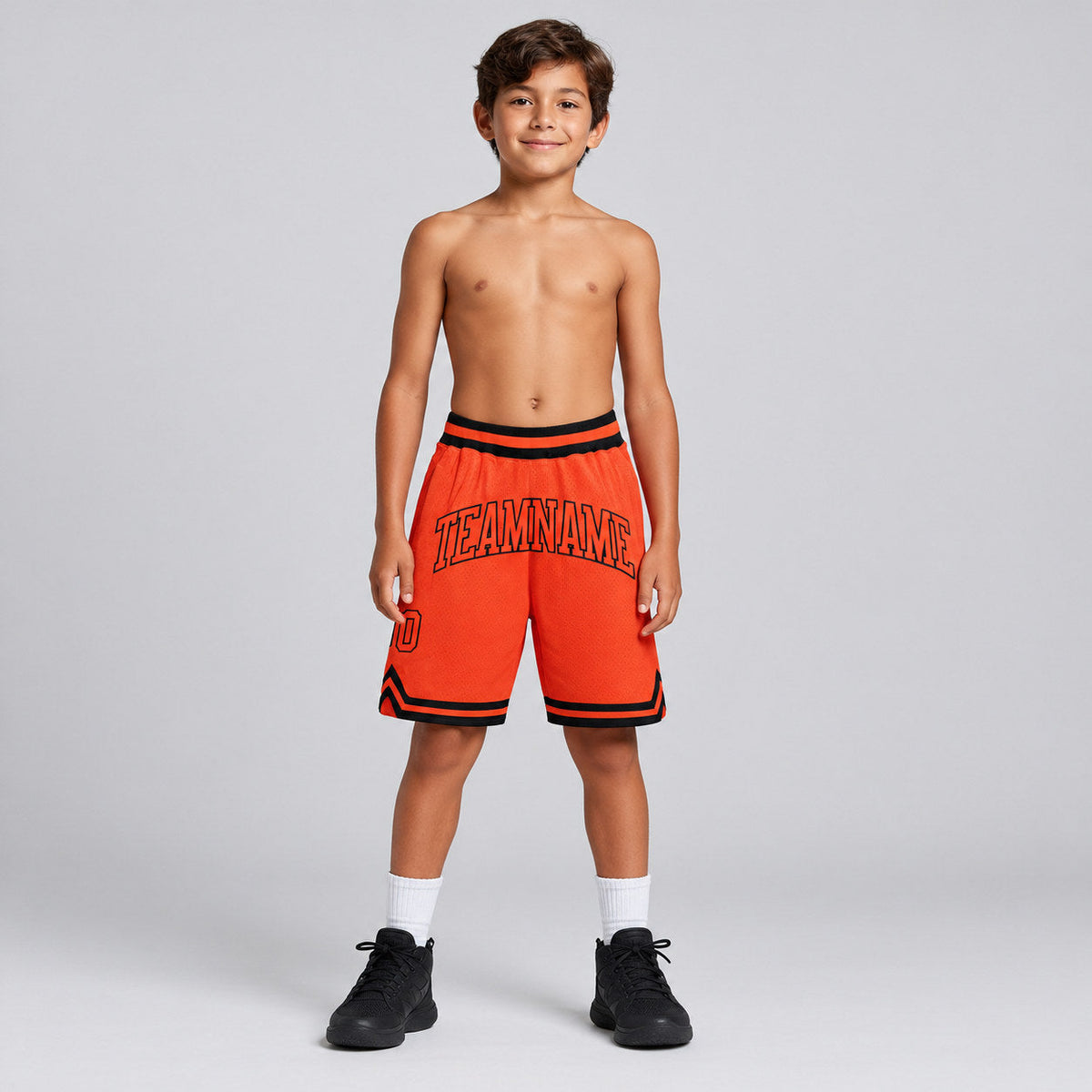 Custom Orange Authentic Throwback Basketball Shorts with Orange and Black Lettering youth size worn by child model