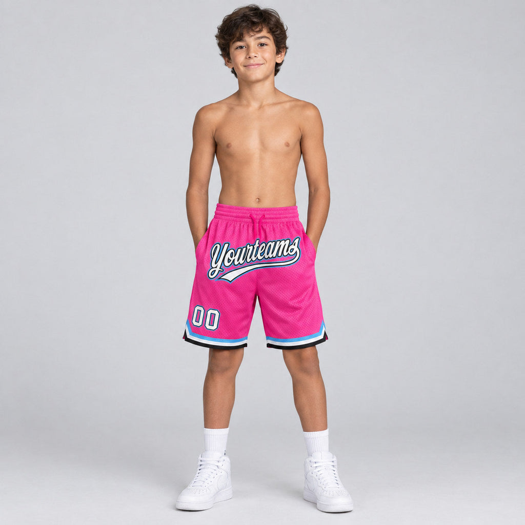 Custom Pink and White Authentic Throwback Basketball Shorts with Black and Light Blue Lettering youth size worn by child model