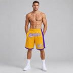 Custom Gold Authentic Basketball Shorts with White and Purple Lettering worn by male model