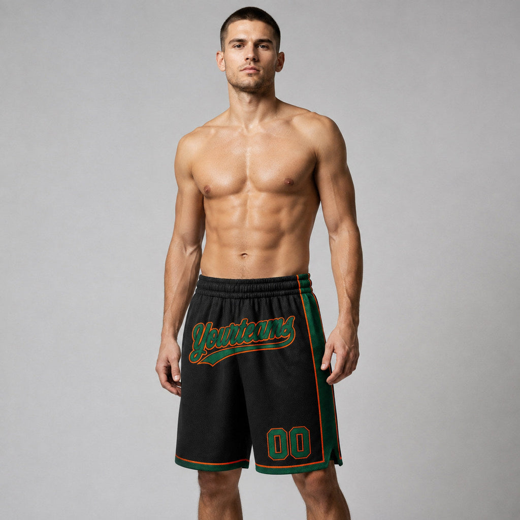 Custom Black Authentic Basketball Shorts with Kelly Green and Orange Lettering worn by male model