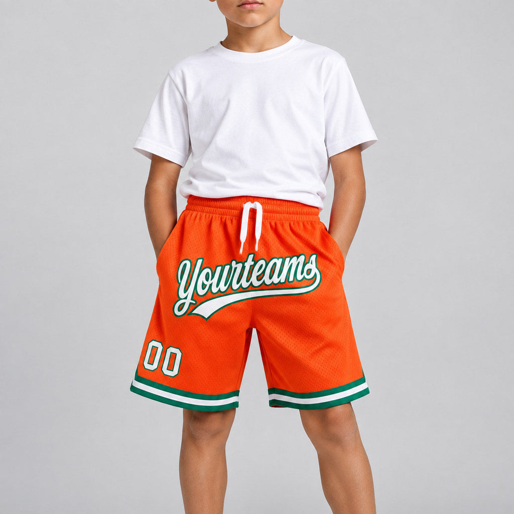 Custom Orange Authentic Throwback Basketball Shorts with White and Kelly Green Lettering youth size worn by child model