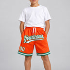 Custom Orange Authentic Throwback Basketball Shorts with White and Kelly Green Lettering youth size worn by child model