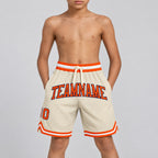 Custom Cream Authentic Throwback Basketball Shorts with Orange and Navy Lettering youth size worn by child model