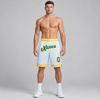 Custom White and Kelly Green Basketball Shorts with Kelly Green and Gold Lettering worn by male model