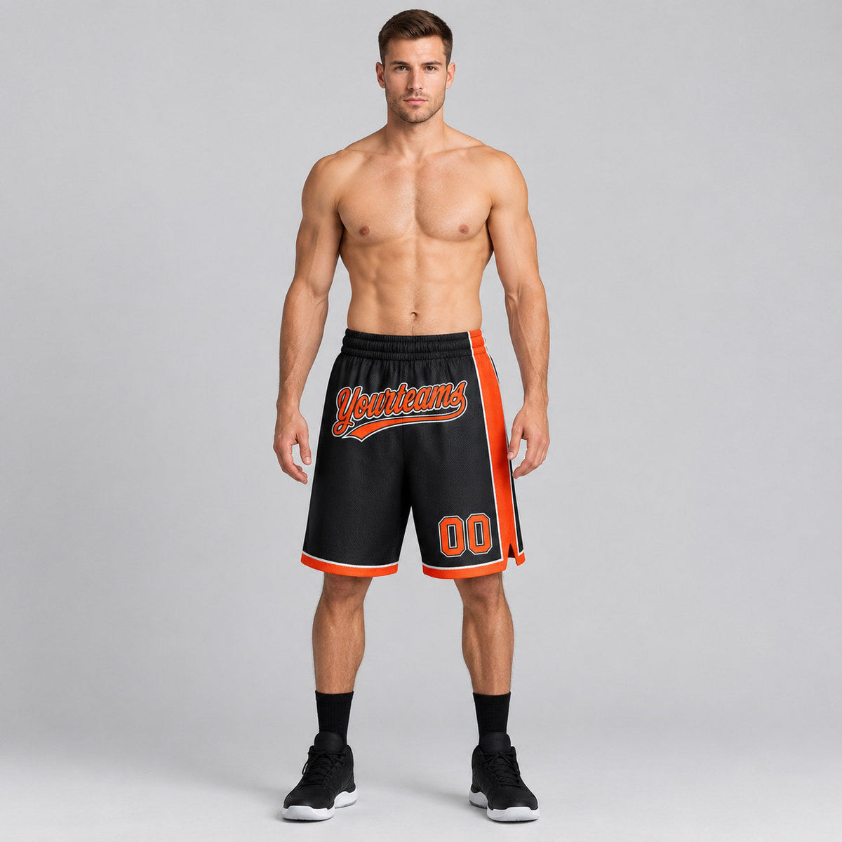 Custom Black Authentic Basketball Shorts with Orange and White Lettering worn by male model