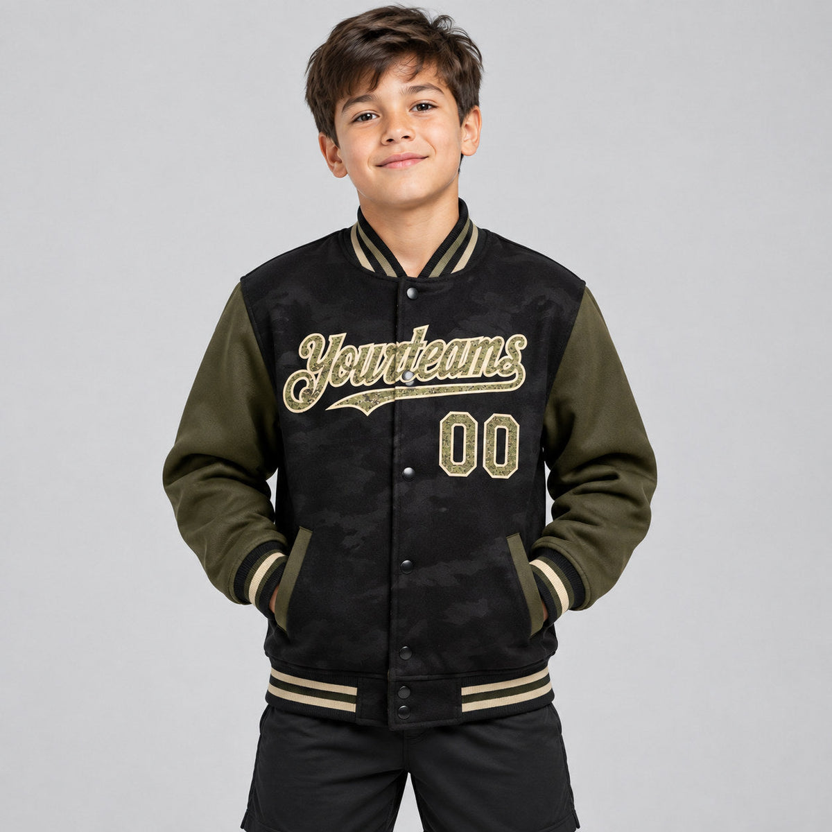 Custom Black Camo Full Snap Bomber Two Tone Varsity Jacket with Olive and Cream Accents youth size worn by child model