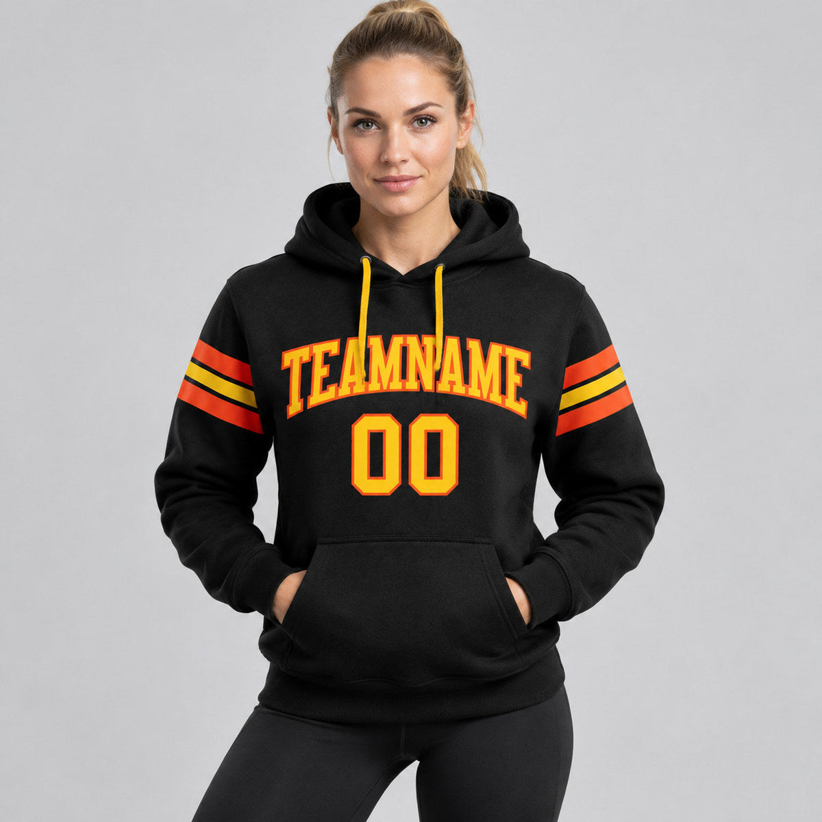 Custom Black Football Pullover Hoodie with Yellow and Orange Lettering worn by female model