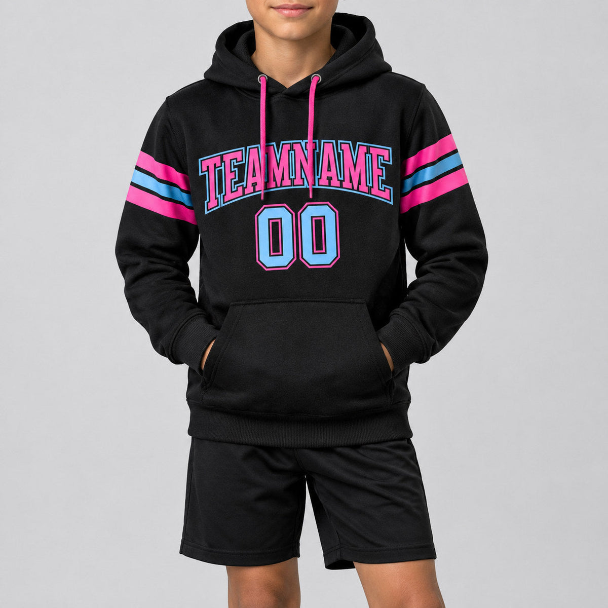 Custom Black Football Pullover Hoodie with Light Blue and Pink Lettering youth size worn by child model