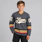 Custom Steel Gray Hockey Jersey with White and Old Gold Lettering youth size worn by child model