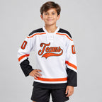 Custom White Lace Neck Hockey Jersey with Orange and Black Lettering Design 1447 youth size worn by child model