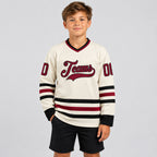 Custom Cream Hockey Jersey with Maroon and Black Lettering youth size worn by child model