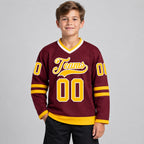 Custom Burgundy Hockey Jersey with Gold and White Lettering Design 0047 youth size worn by child model