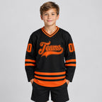 Custom Black Hockey Jersey with Orange Lettering Design 2453 youth size worn by child model
