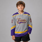 Custom Gray Lace Neck Hockey Jersey with Purple and Gold Lettering youth size worn by child model