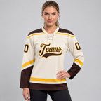Custom Cream Lace Neck Hockey Jersey with Brown and Gold Lettering worn by female model