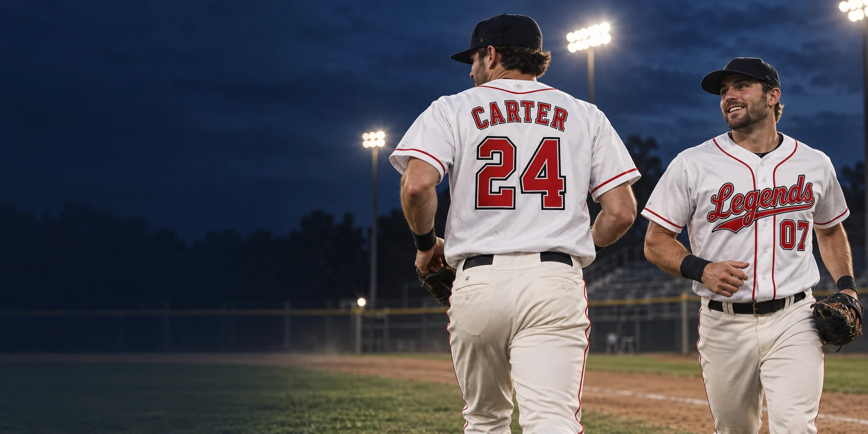 Illustrative campaign image of two adult baseball teammates in white and red personalized jerseys on a field under stadium lights